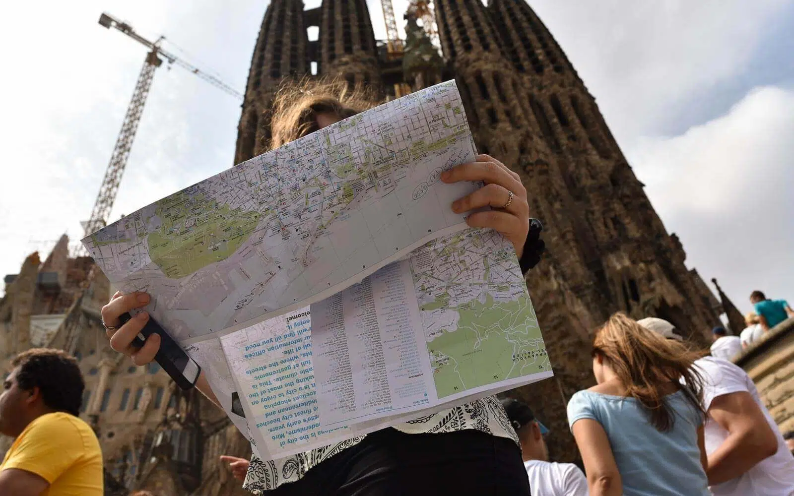 a woman looks through her barcelona in 3 days itinerary at sagrada familia