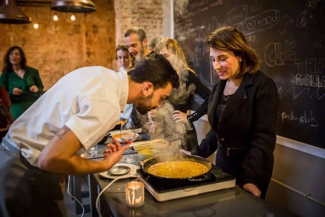 a tourist makes paella at a cooking workshop in barcelona