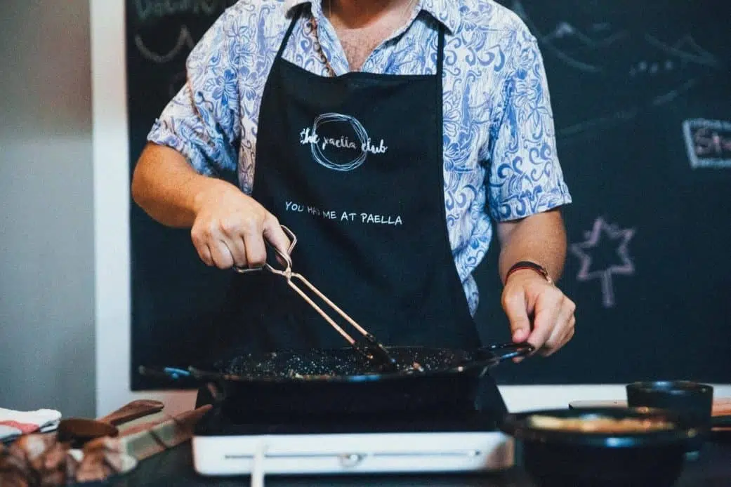 a client participates in a paella cooking class in barcelona