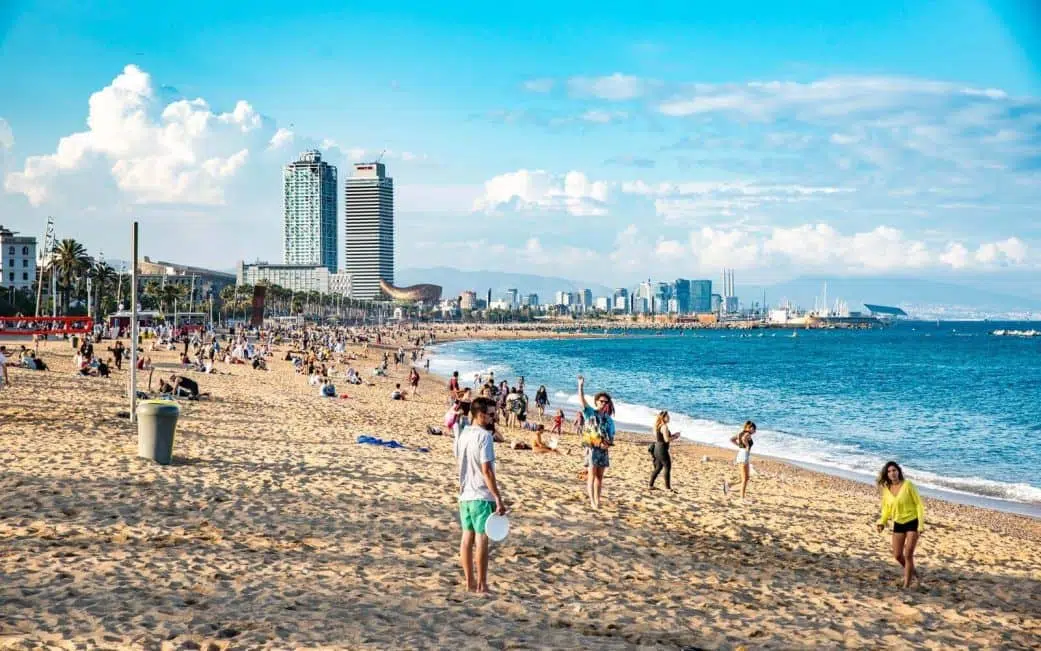 locals play frisbee and volleyball on one of barcelona's most popular beaches