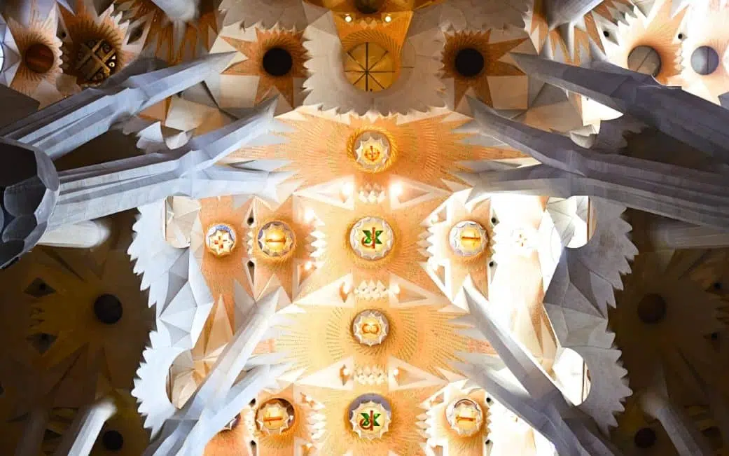 tree-shaped columns holding up a lighted ceiling at the sagrada familia in barcelona spain