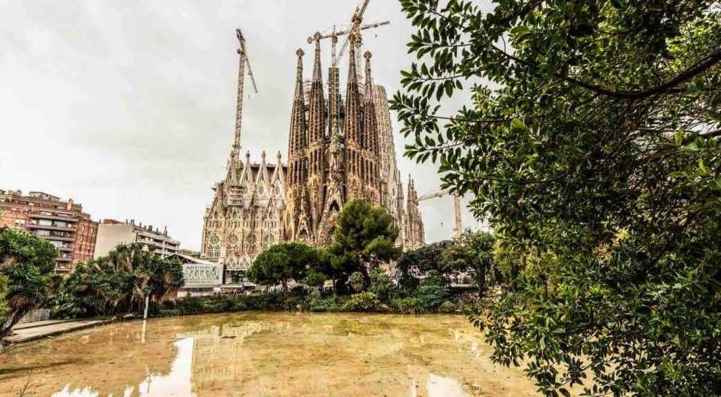 sagrada familia view with water reflection in barcelona spain