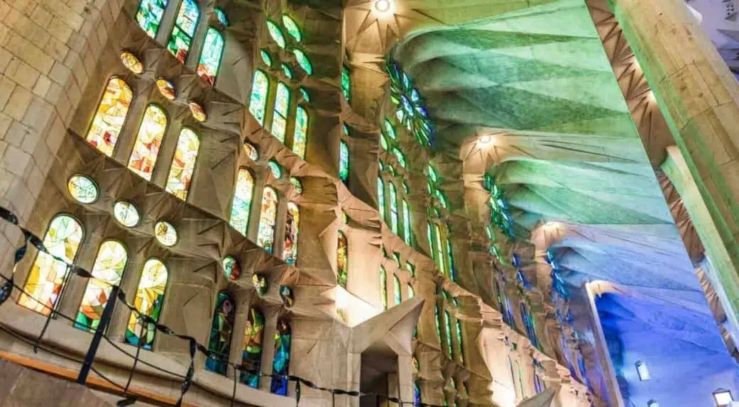 green and blue light entering through stained glass windows at sagrada familia church in barcelona spain