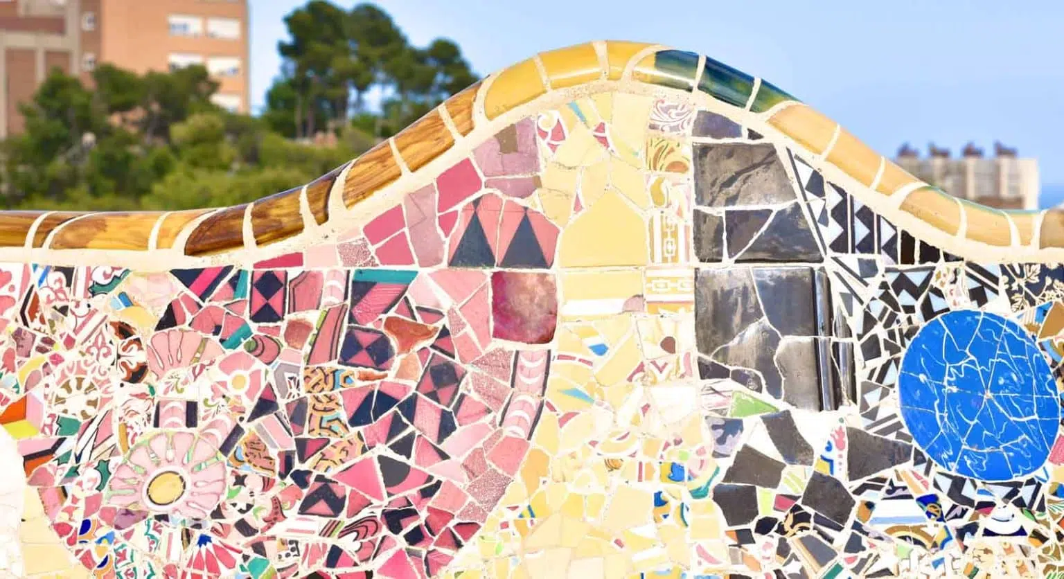 pink yellow and black mosaic bench at park guell