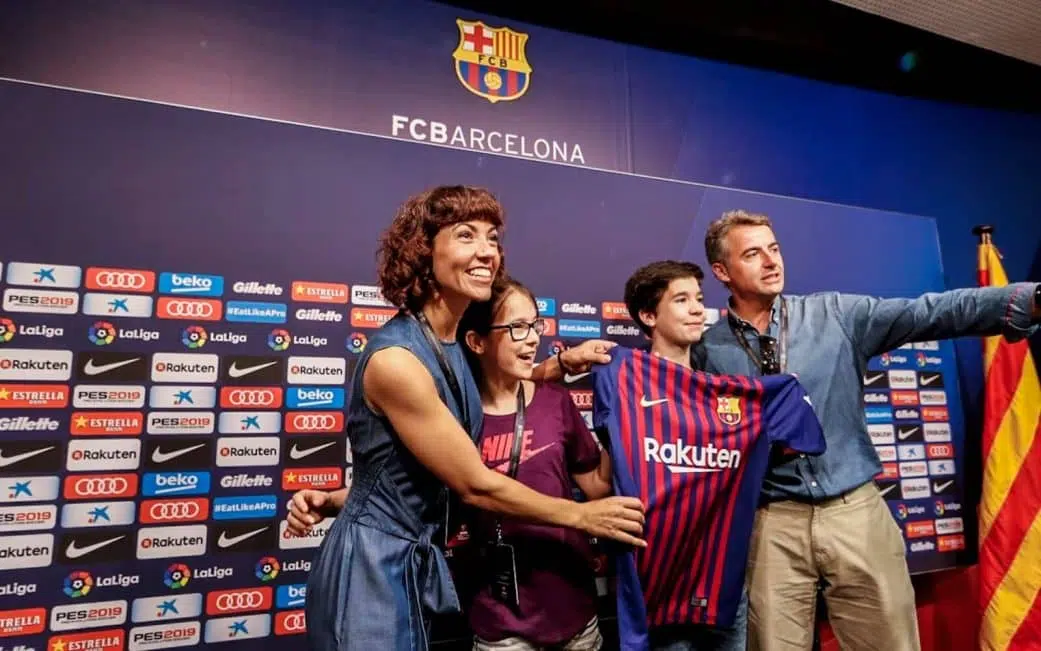 family posing in the camp nou press area on the camp nou experience tour