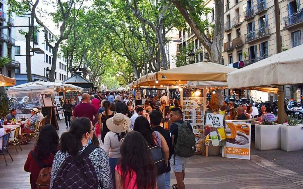 tourists walking through restaurants on la rambla in barcelona spain