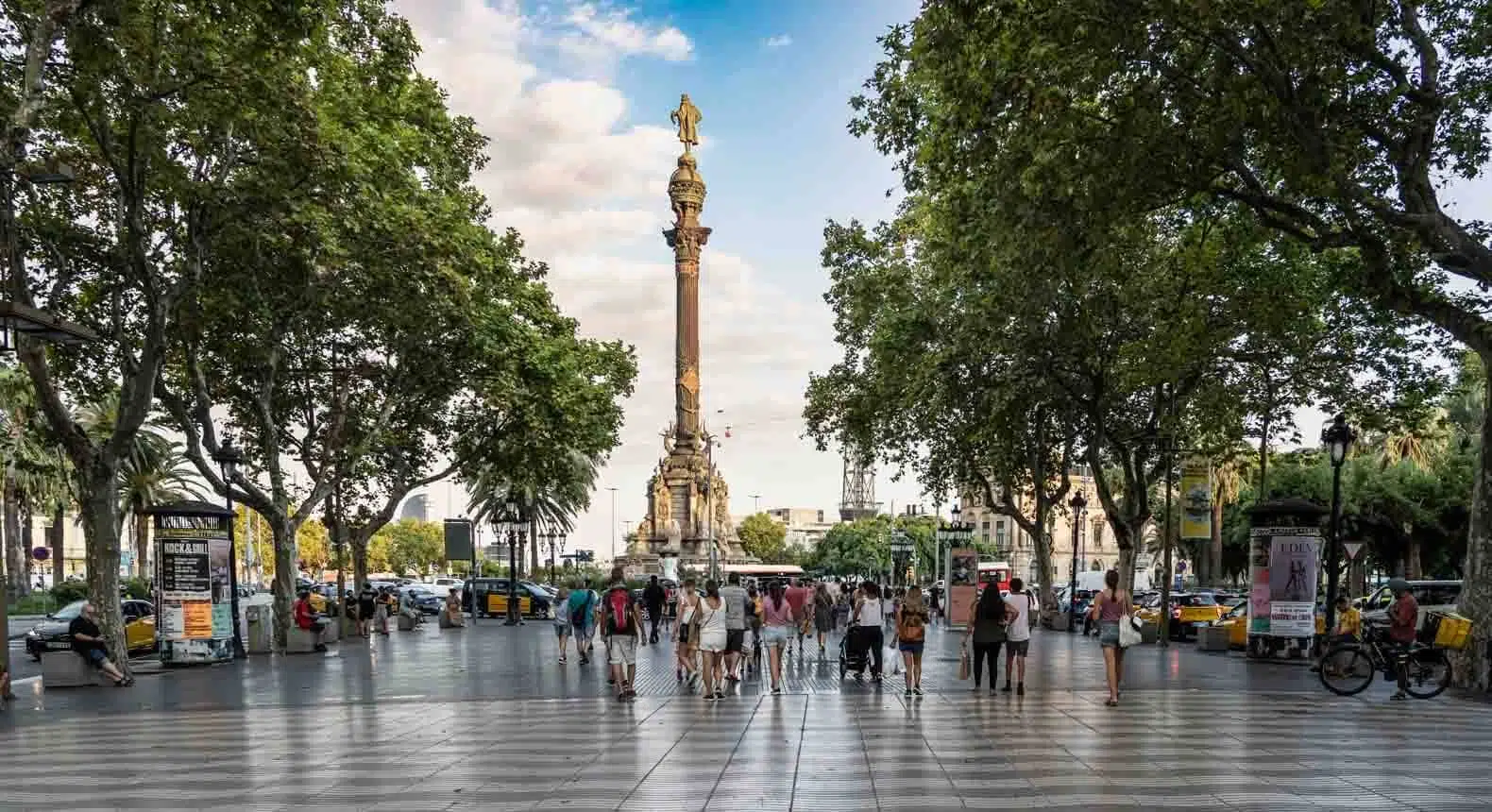 tourists walking toward the columbus statue along la rambla in barcelona spain