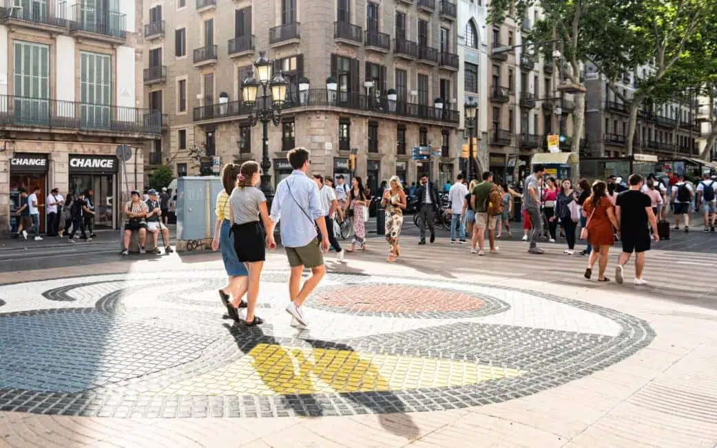 tourists walking along the joan miro mosaic on la rambla in barcelona spain