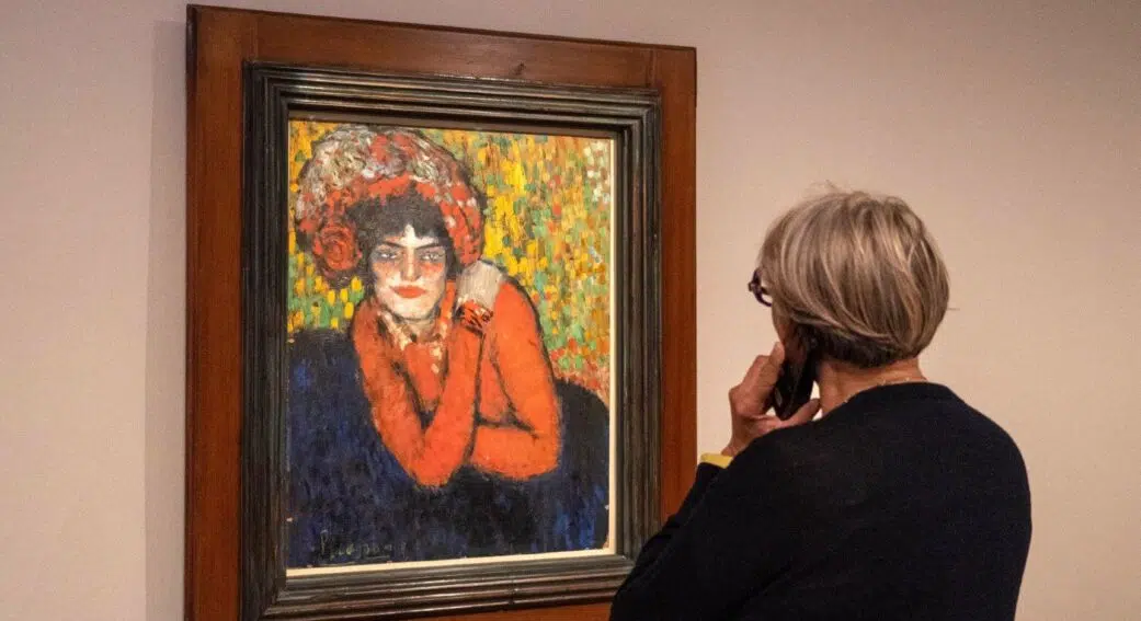 woman listening to the audio guide and looking at a portrait at the picasso museum barcelona