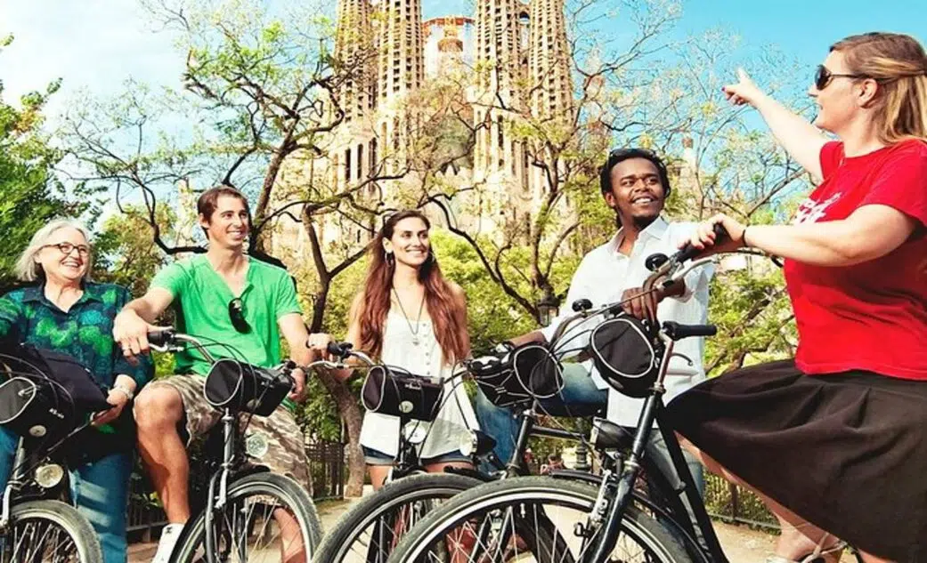 a group listens to their guide outside sagrada familia on a barcelona bike tour.