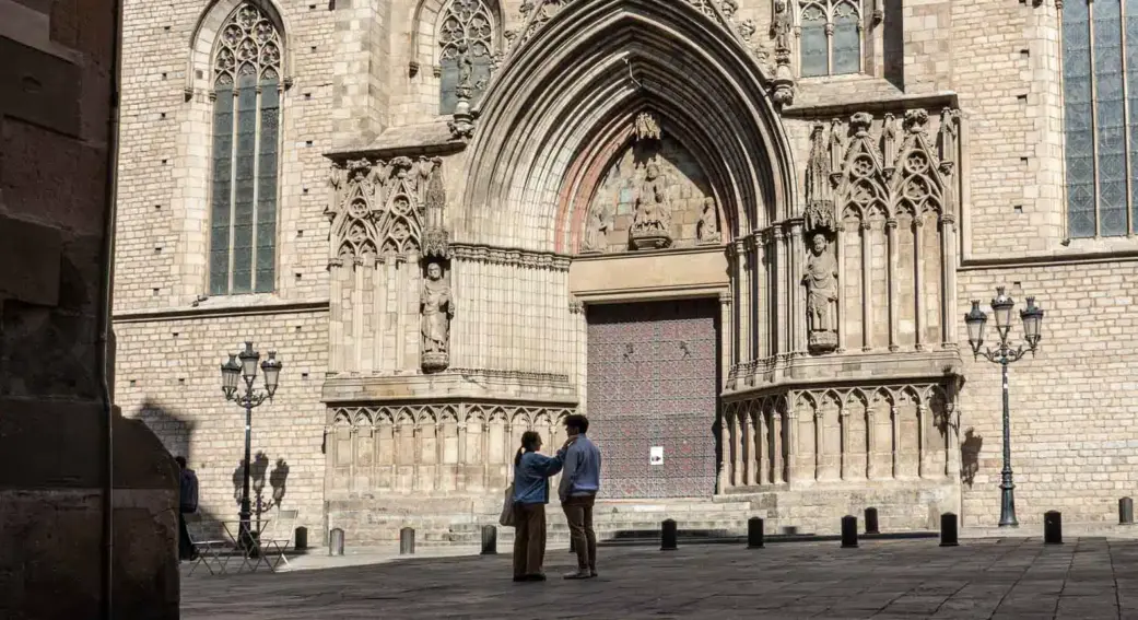 two tourists looking at the side door of the santa maria del mar cathedral