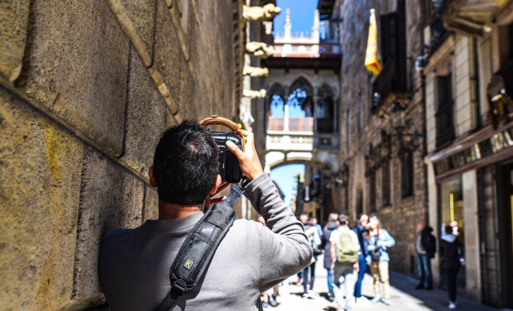 tourist taking a photo of bishop's bridge in barcelona