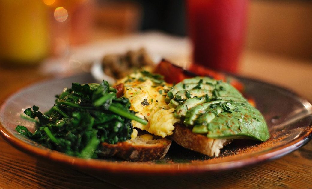 a plate with an avocado toast and a spinach and egg toast at caravelle in barcelona