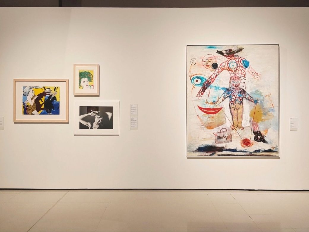 artworks displayed on a white gallery wall, including colorful pop-art portraits on the left and a large abstract painting featuring surreal faces and figures on the right at mnac museum in barcelona